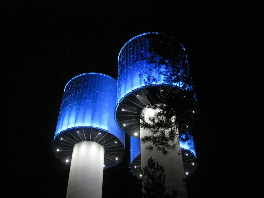 Taskalinmäen vesitornit sinisessä valaistuksessa öiseen aikaan.