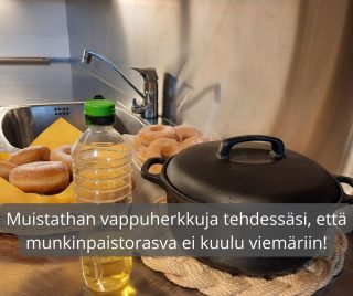 Tiskipöydällä munkkeja, paistorasvapullo sekä kattila. Kuvassa teksti: Muistathan vappuherkkuja tehdessäsi, että munkinpaistorasva ei kuulu viemäriin!